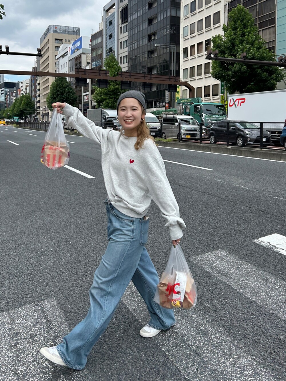 グレー系のスウェット、ブルー系のデニムパンツ、グレー系のニットキャップ/ビーニーを着用したレディースの秋コーディネートの2枚目の写真