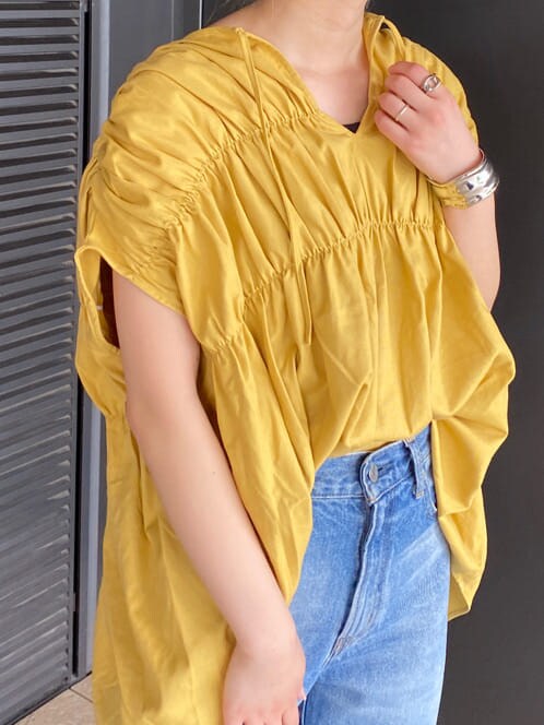 ブルー系のデニムパンツ、イエロー系のシャツ/ブラウス、ブラック系のキャミソールを着用したレディースの夏コーディネートの5枚目の写真