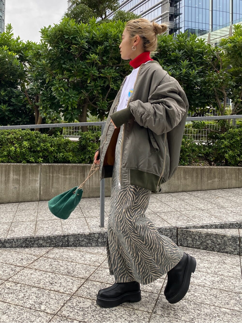 グリーン系のMA-1、レッド系のニット/セーター、ホワイト系のTシャツ/カットソーを着用したレディースの秋コーディネートの3枚目の写真