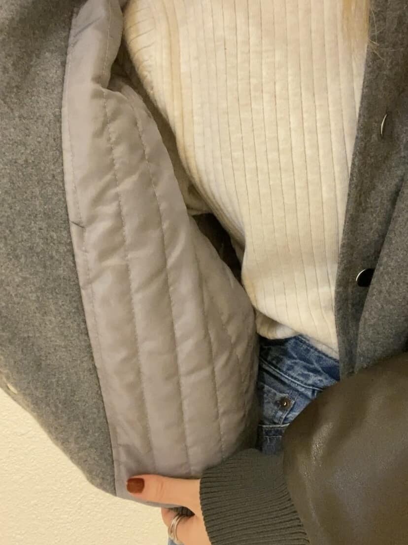 グレー系のブルゾン、ホワイト系のニット/セーター、ブルー系のデニムパンツを着用したレディースの秋コーディネートの7枚目の写真