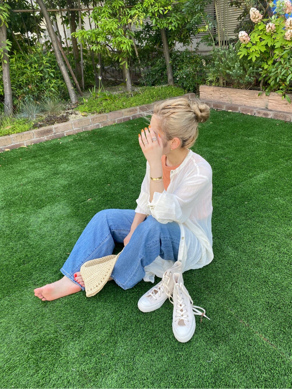 グリーン系のサンダル、ブルー系のデニムパンツ、ホワイト系のスニーカーを着用したレディースの夏コーディネートの7枚目の写真