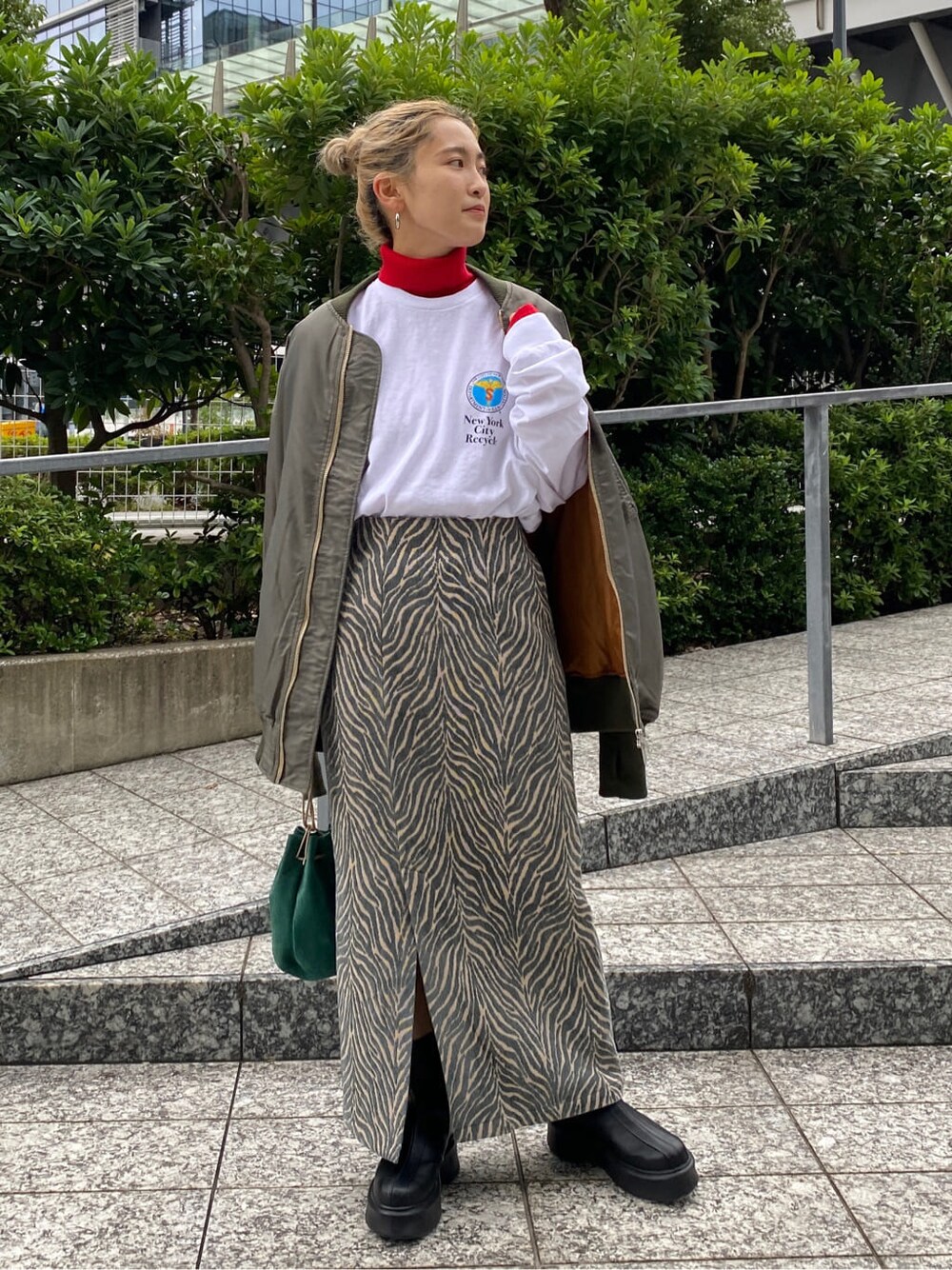 グリーン系のMA-1、レッド系のニット/セーター、ホワイト系のTシャツ/カットソーを着用したレディースの秋コーディネートの2枚目の写真