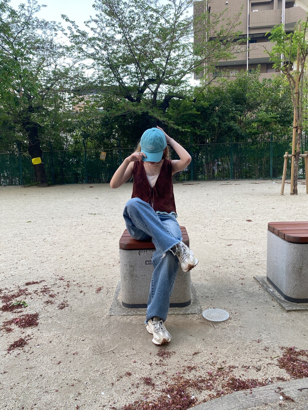 ブラウン系のニット/セーター、ブルー系のデニムパンツを着用したレディースの春コーディネートの2枚目の写真