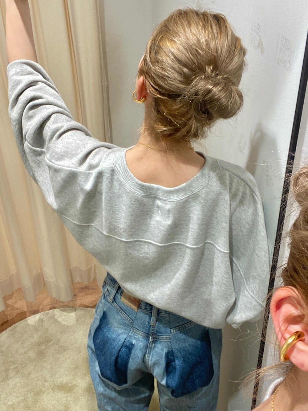 グレー系のスウェット、ブルー系のデニムパンツを着用したレディースの冬コーディネートの4枚目の写真