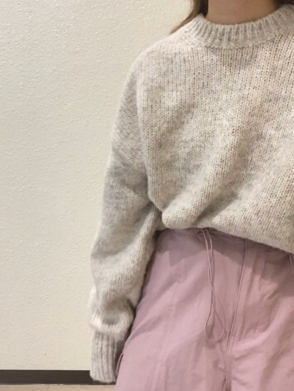 ホワイト系のニット/セーター、ピンク系のカーゴパンツ、ブルー系のキャップを着用したレディースの冬コーディネートの5枚目の写真