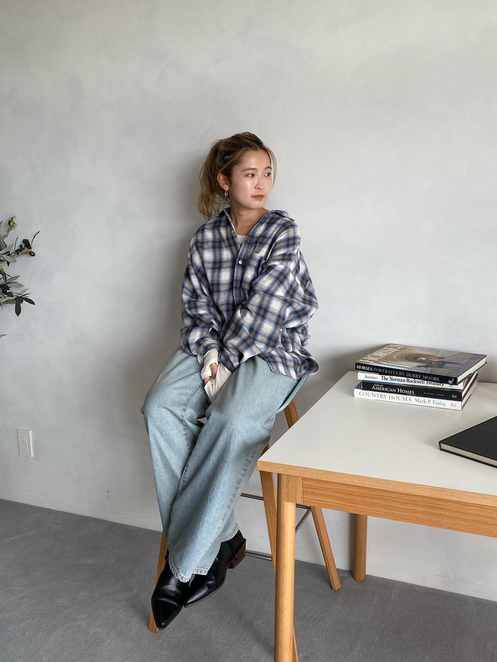 ホワイト系のシャツ/ブラウス、ブルー系のデニムパンツ、ブラック系のブーツを着用したレディースの秋コーディネートの2枚目の写真