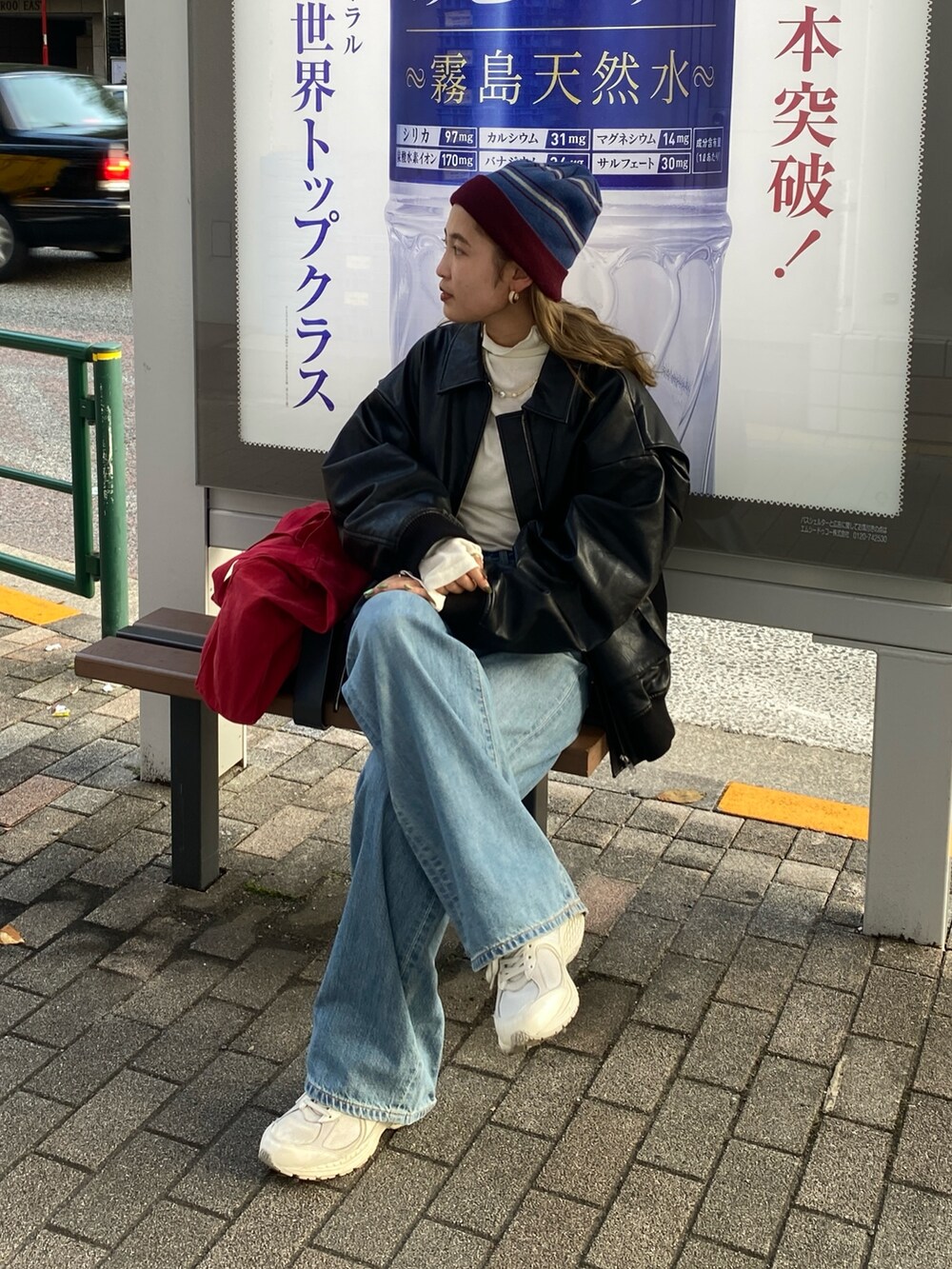 ブラック系のブルゾン、ホワイト系のTシャツ/カットソー、レッド系のトートバッグを着用したレディースの秋コーディネートの3枚目の写真