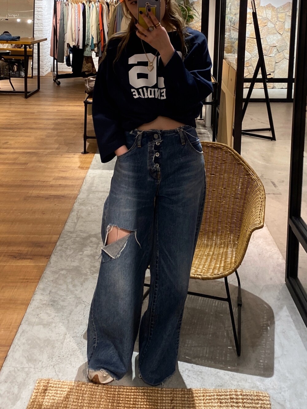 ブルー系のTシャツ/カットソー、ブルー系のデニムパンツ、オレンジ系のキャップを着用したレディースの春コーディネートの5枚目の写真