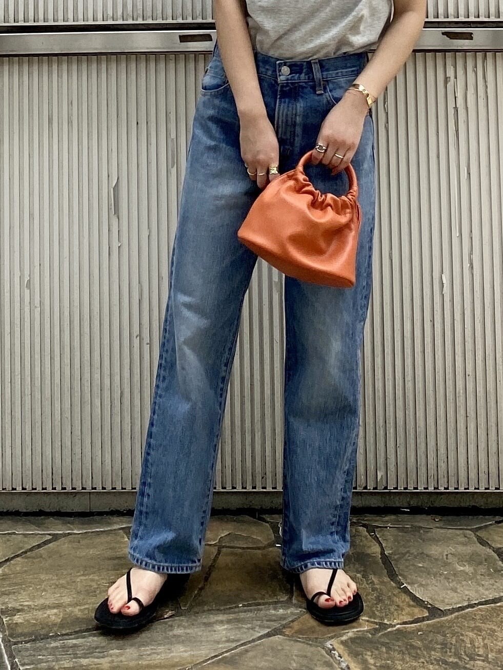 ブルー系のデニムパンツ、ブラック系のサンダル、グレー系のTシャツ/カットソーを着用したレディースの夏コーディネートの7枚目の写真