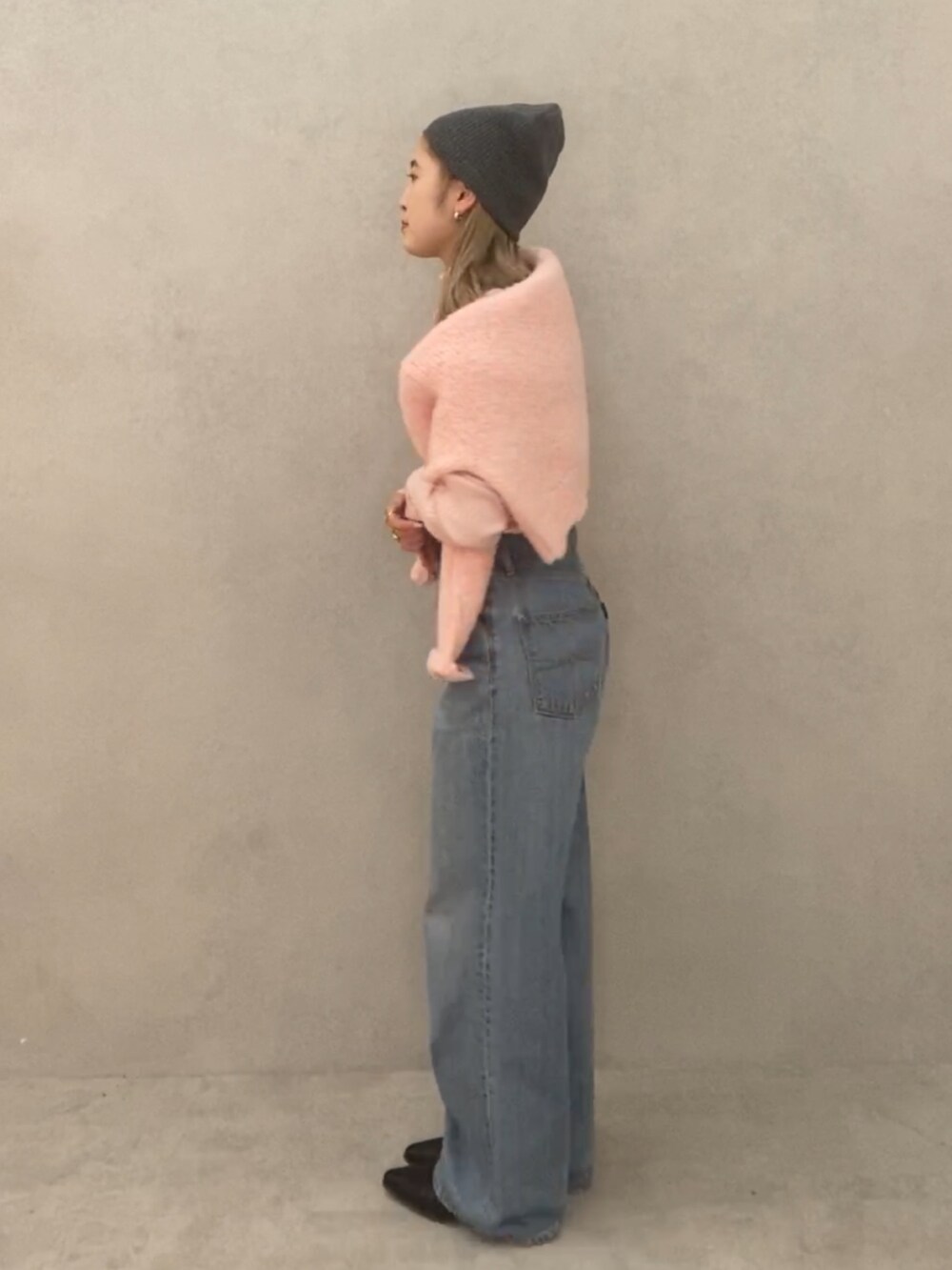 ピンク系のニット/セーター、ピンク系のニット/セーター、ブルー系のデニムパンツを着用したレディースの冬コーディネートの2枚目の写真