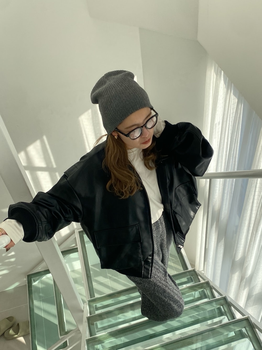 ブラック系のブルゾン、グレー系のその他パンツ、ホワイト系のTシャツ/カットソーを着用したレディースの冬コーディネートの4枚目の写真