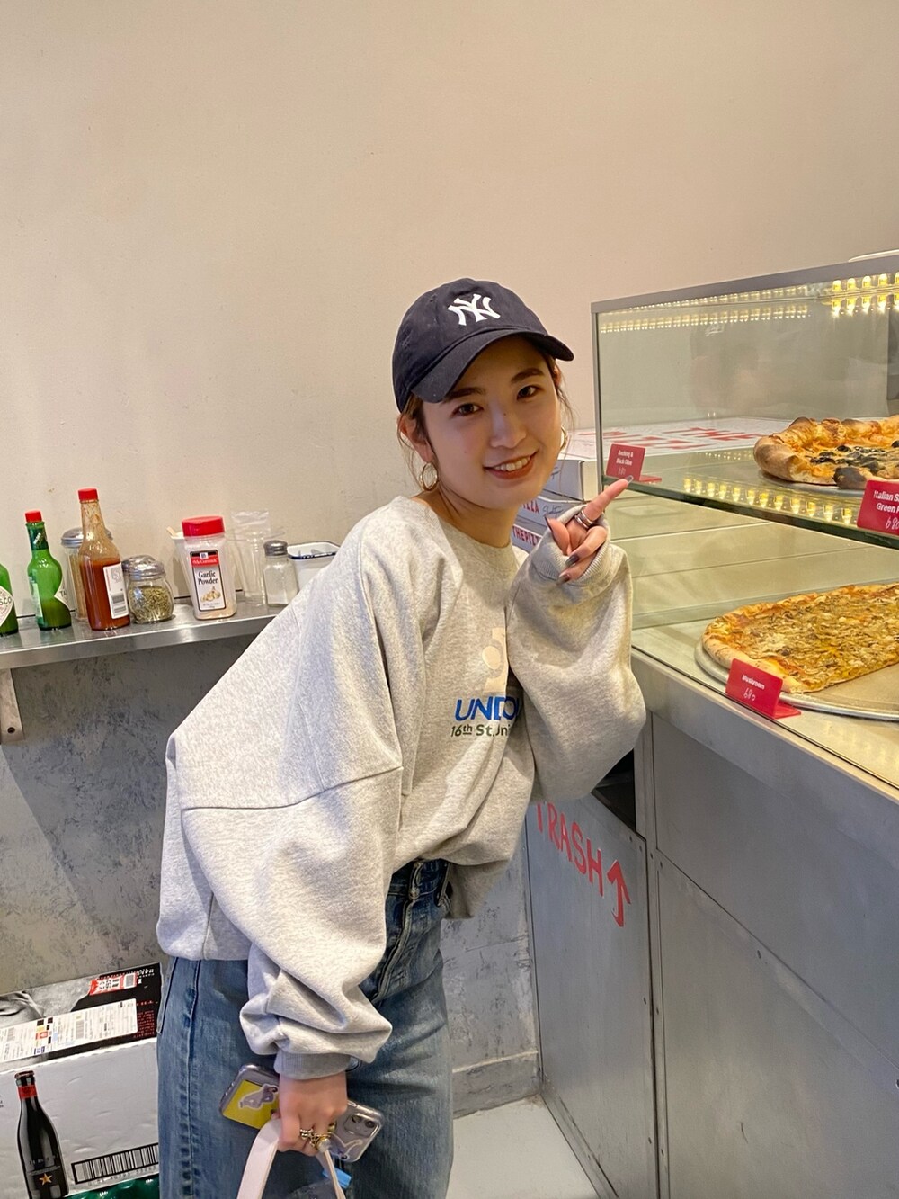 グレー系のスウェット、ブルー系のデニムパンツを着用したレディースの冬コーディネートの2枚目の写真