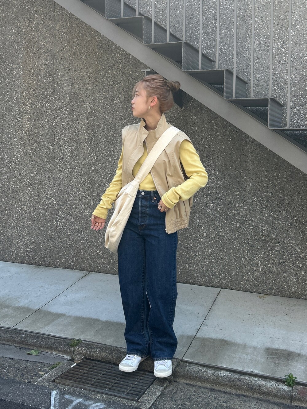 ブルー系のショルダーバッグ、ベージュ系のベスト、グリーン系のTシャツ/カットソーを着用したレディースの夏コーディネートの3枚目の写真