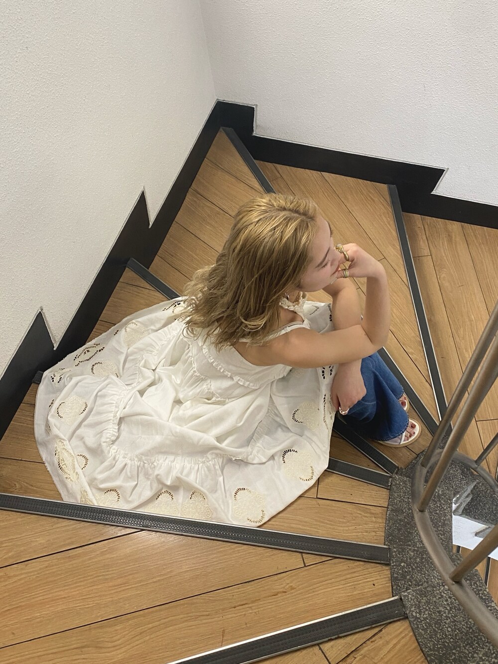 ホワイト系のワンピース、ホワイト系のタンクトップ、ブルー系のデニムパンツを着用したレディースの春コーディネートの2枚目の写真