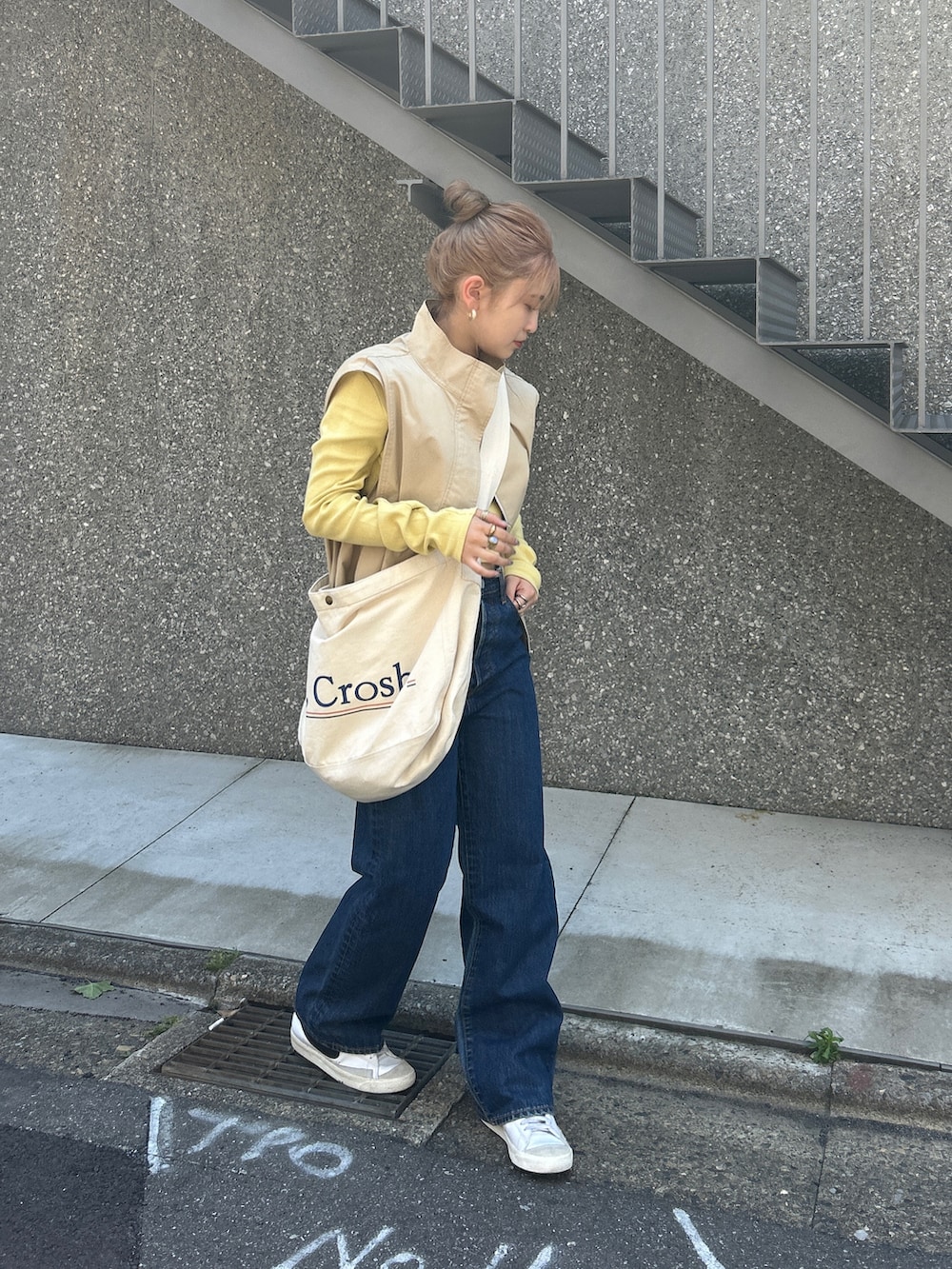 ブルー系のショルダーバッグ、ベージュ系のベスト、グリーン系のTシャツ/カットソーを着用したレディースの夏コーディネートの2枚目の写真