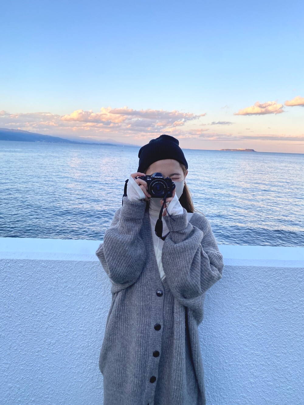 グレー系のカーディガン/ボレロ、ホワイト系のTシャツ/カットソー、ブラック系のニットキャップ/ビーニーを着用したレディースの冬コーディネートの6枚目の写真