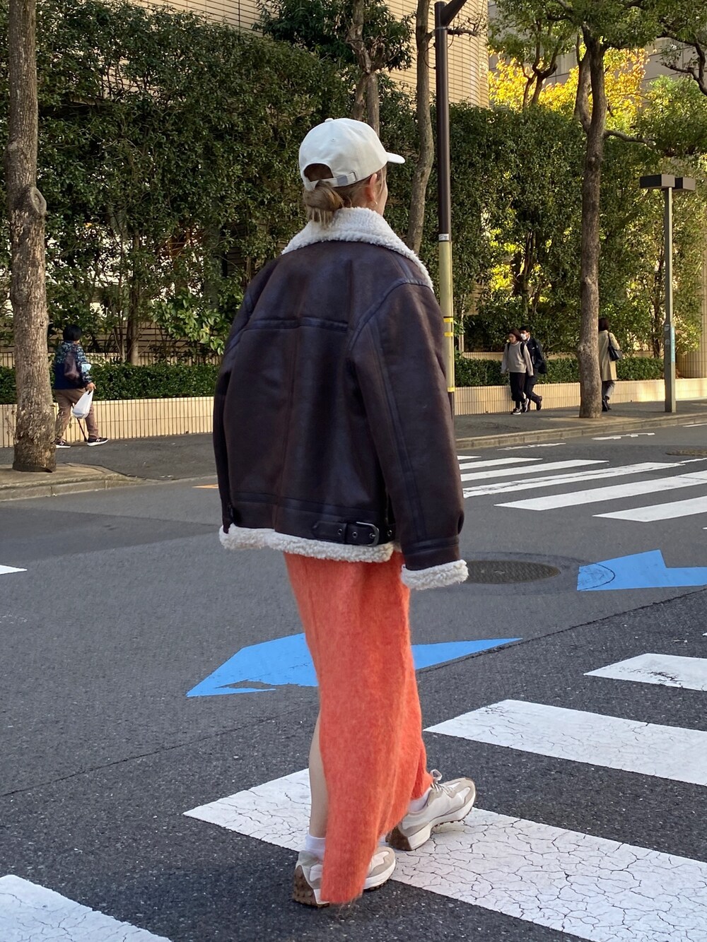 オレンジ系のワンピース、ブラウン系のブルゾン、ホワイト系のTシャツ/カットソーを着用したレディースの冬コーディネートの4枚目の写真