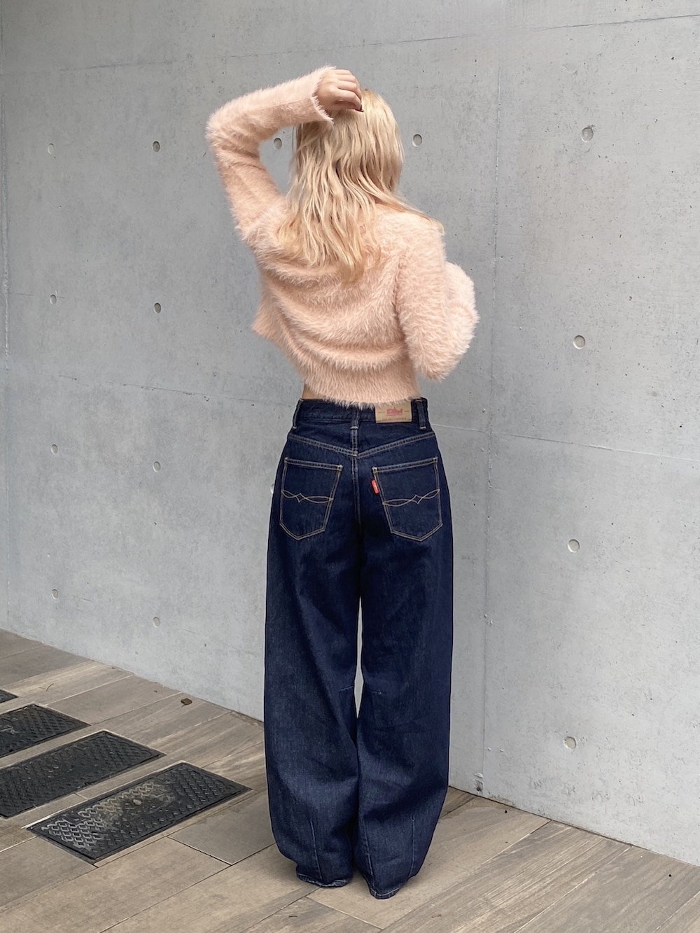オレンジ系のカーディガン/ボレロ、ブルー系のデニムパンツ、シルバー系のパンプスを着用したレディースの秋コーディネートの3枚目の写真