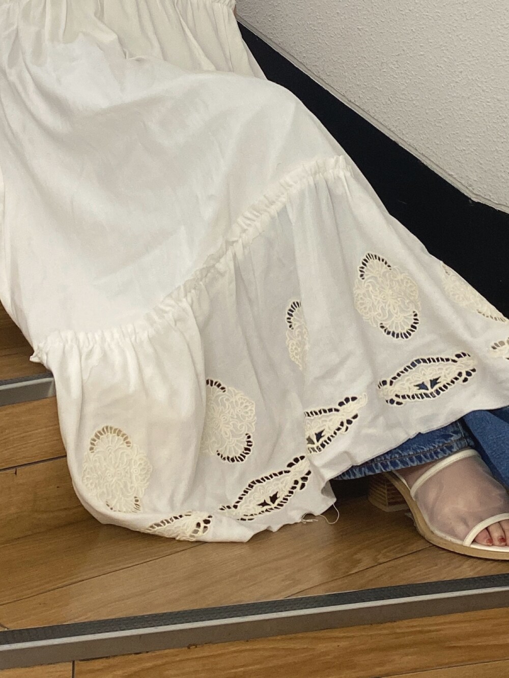 ホワイト系のワンピース、ホワイト系のタンクトップ、ブルー系のデニムパンツを着用したレディースの春コーディネートの3枚目の写真