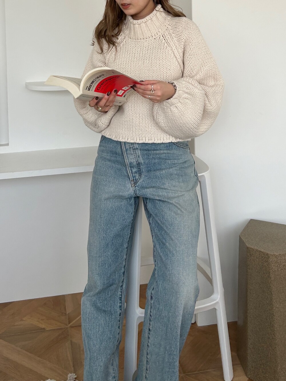 ホワイト系のニット/セーター、ブルー系のデニムパンツを着用したレディースの冬コーディネートの2枚目の写真