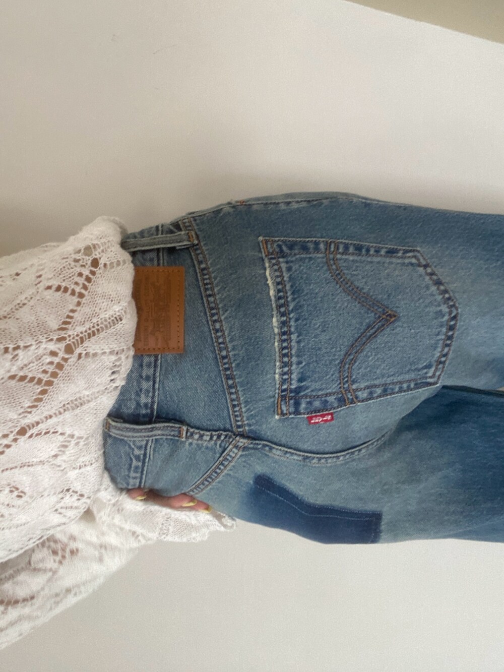 ホワイト系のニット/セーター、ブルー系のデニムパンツ、ブラック系のショルダーバッグを着用したレディースの夏コーディネートの3枚目の写真