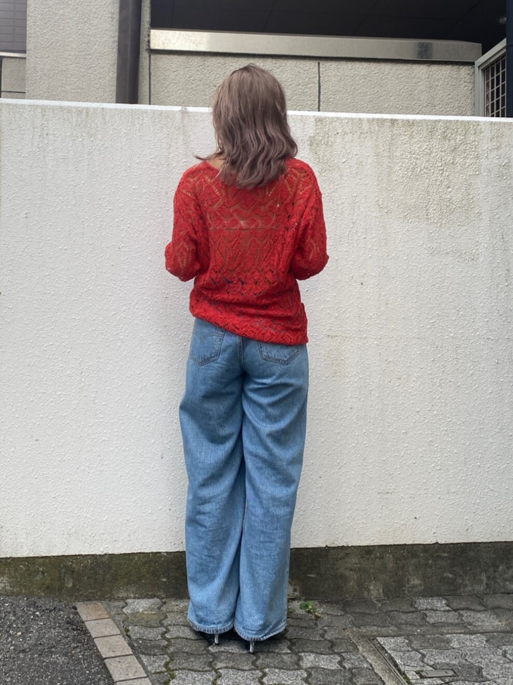 ブルー系のデニムパンツ、シルバー系のその他シューズ、オレンジ系のニット/セーターを着用したレディースの夏コーディネートの3枚目の写真