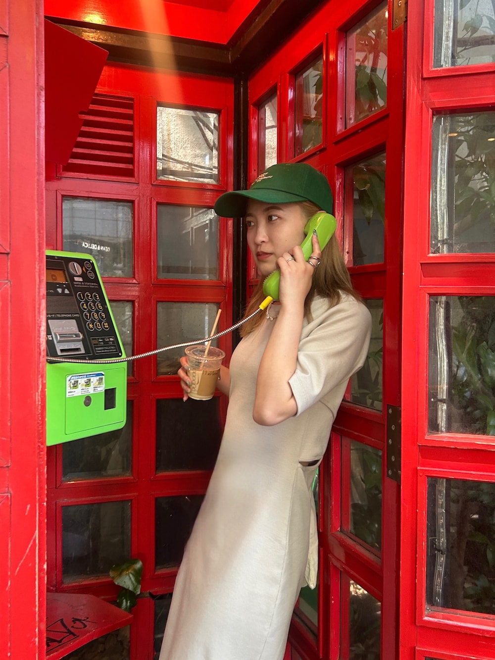 グレー系のワンピース、グリーン系のキャップを着用したレディースの夏コーディネートの2枚目の写真