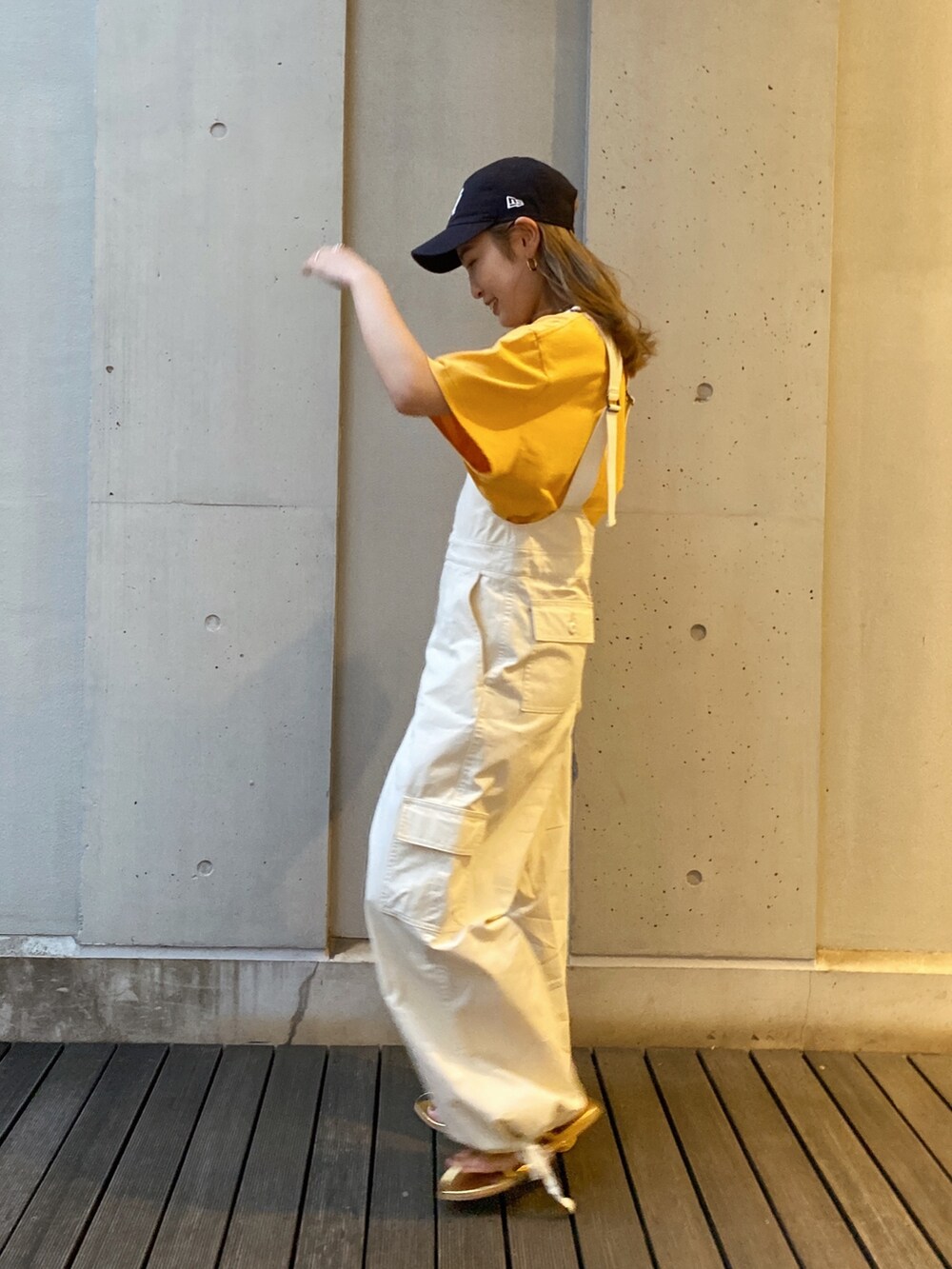 ホワイト系のつなぎ/オールインワン、イエロー系のTシャツ/カットソー、ゴールド系のサンダルを着用したレディースの春コーディネートの2枚目の写真