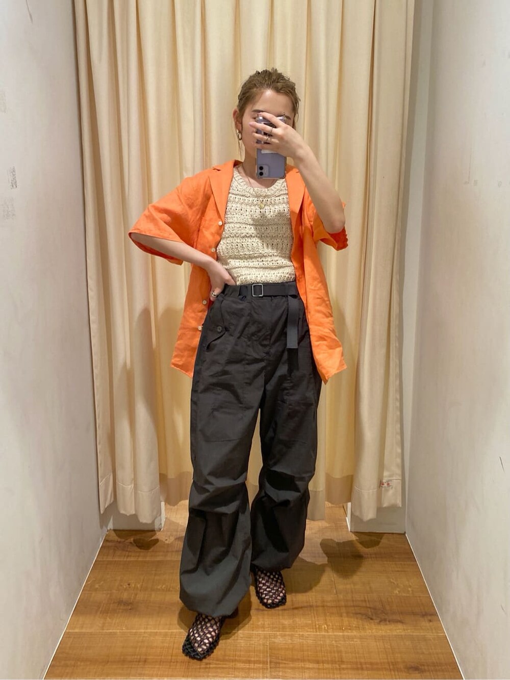 ブラック系のサンダル、ホワイト系のニット/セーター、オレンジ系のシャツ/ブラウスを着用したレディースの春コーディネートの4枚目の写真