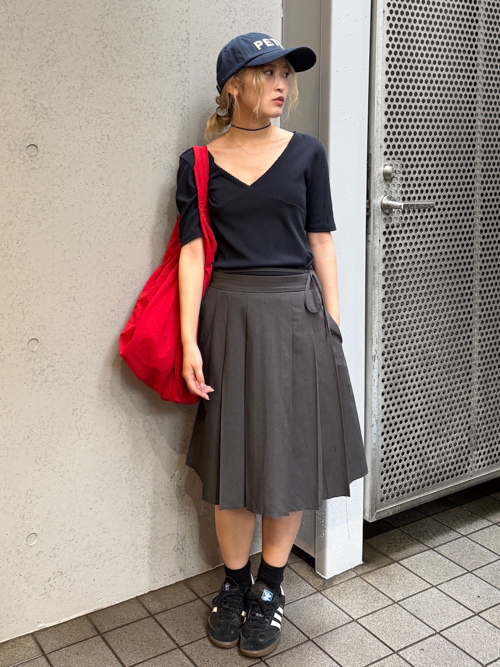 ブラック系のTシャツ/カットソー、レッド系のキャップを着用したレディースの夏コーディネートの2枚目の写真