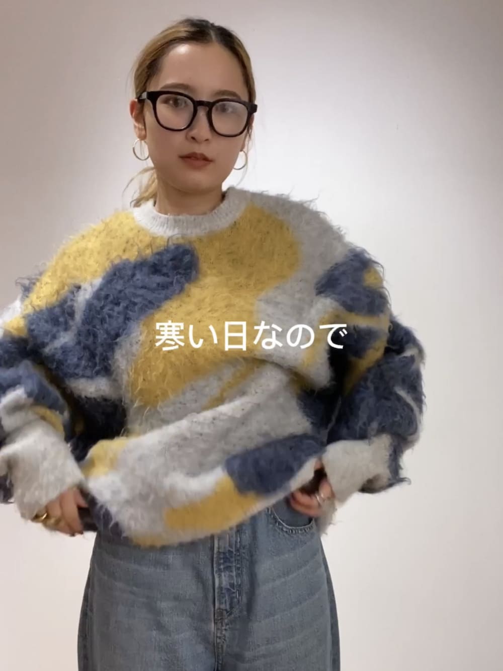 ブルー系のニット/セーター、ブルー系のデニムパンツ、グレー系のニットキャップ/ビーニーを着用したレディースの秋コーディネートの2枚目の写真