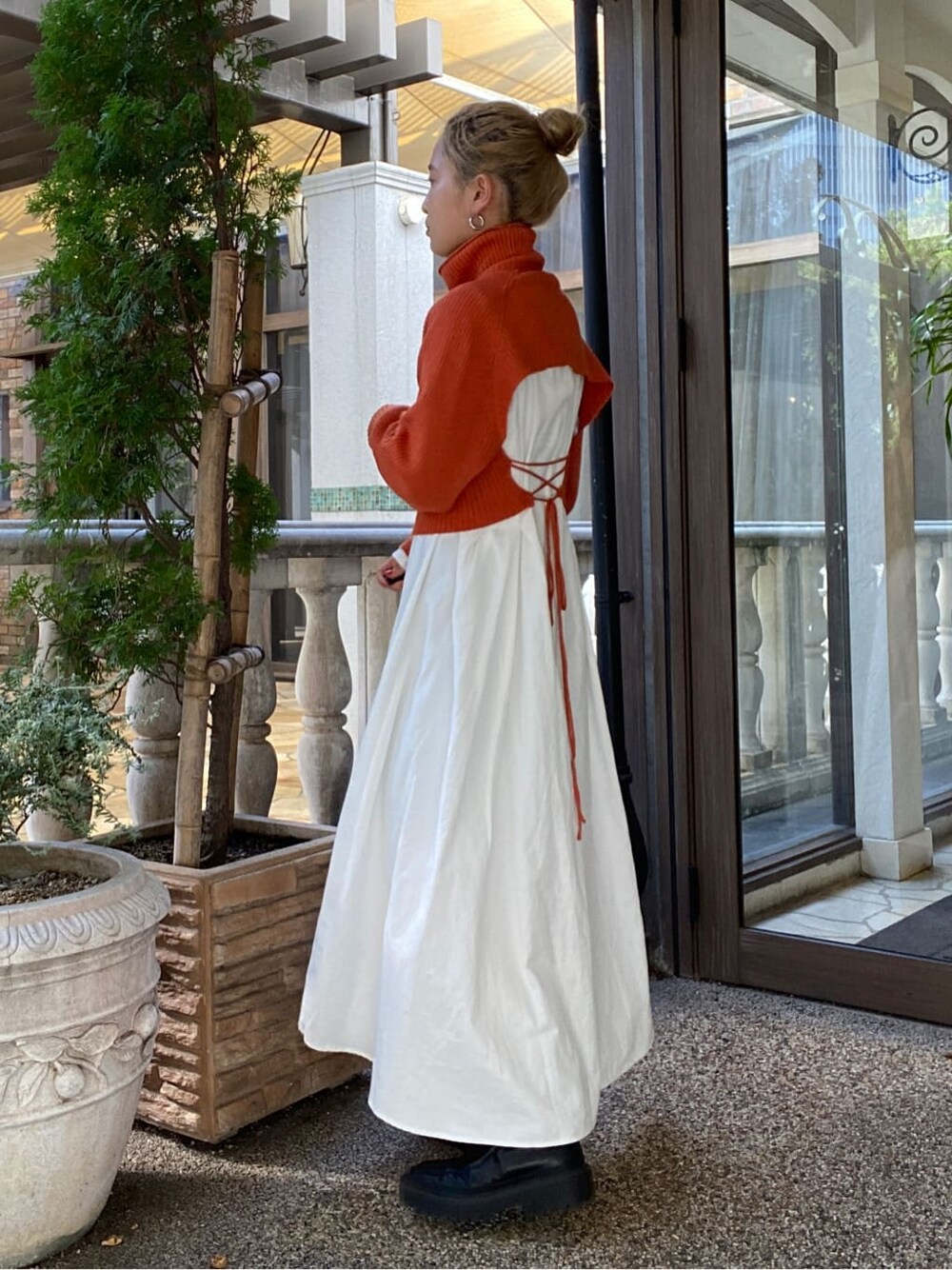 オレンジ系のワンピースを着用したレディースの秋コーディネートの2枚目の写真