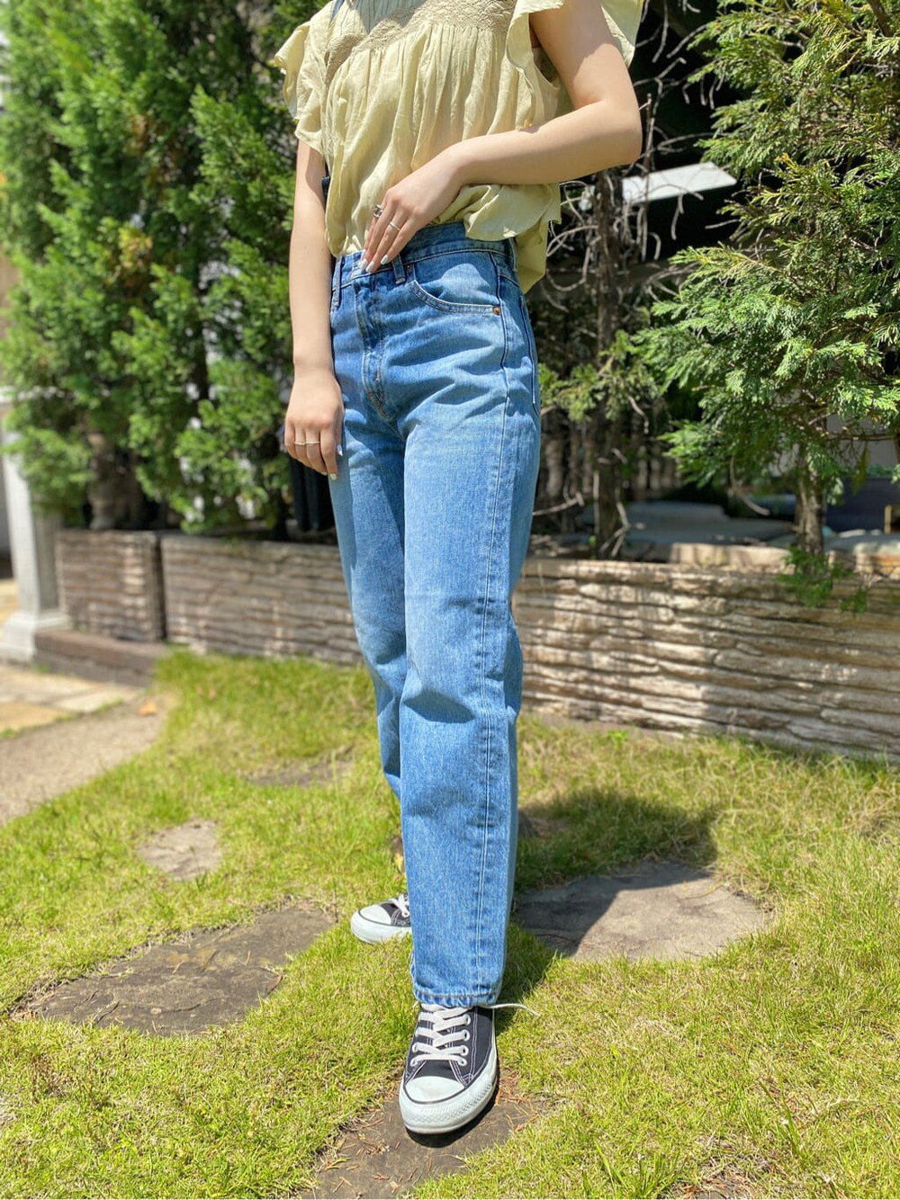 グリーン系のシャツ/ブラウス、ブラック系のショルダーバッグ、ブルー系のデニムパンツを着用したレディースの春コーディネートの4枚目の写真