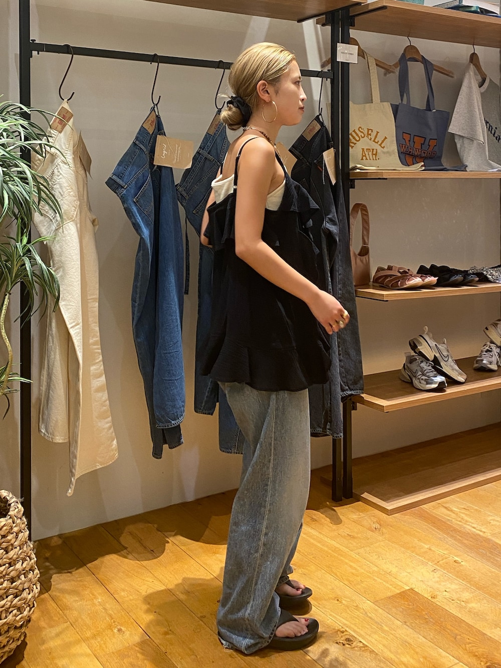 ブラック系のキャミソール、ホワイト系のキャミソール、ブルー系のデニムパンツを着用したレディースの夏コーディネートの3枚目の写真