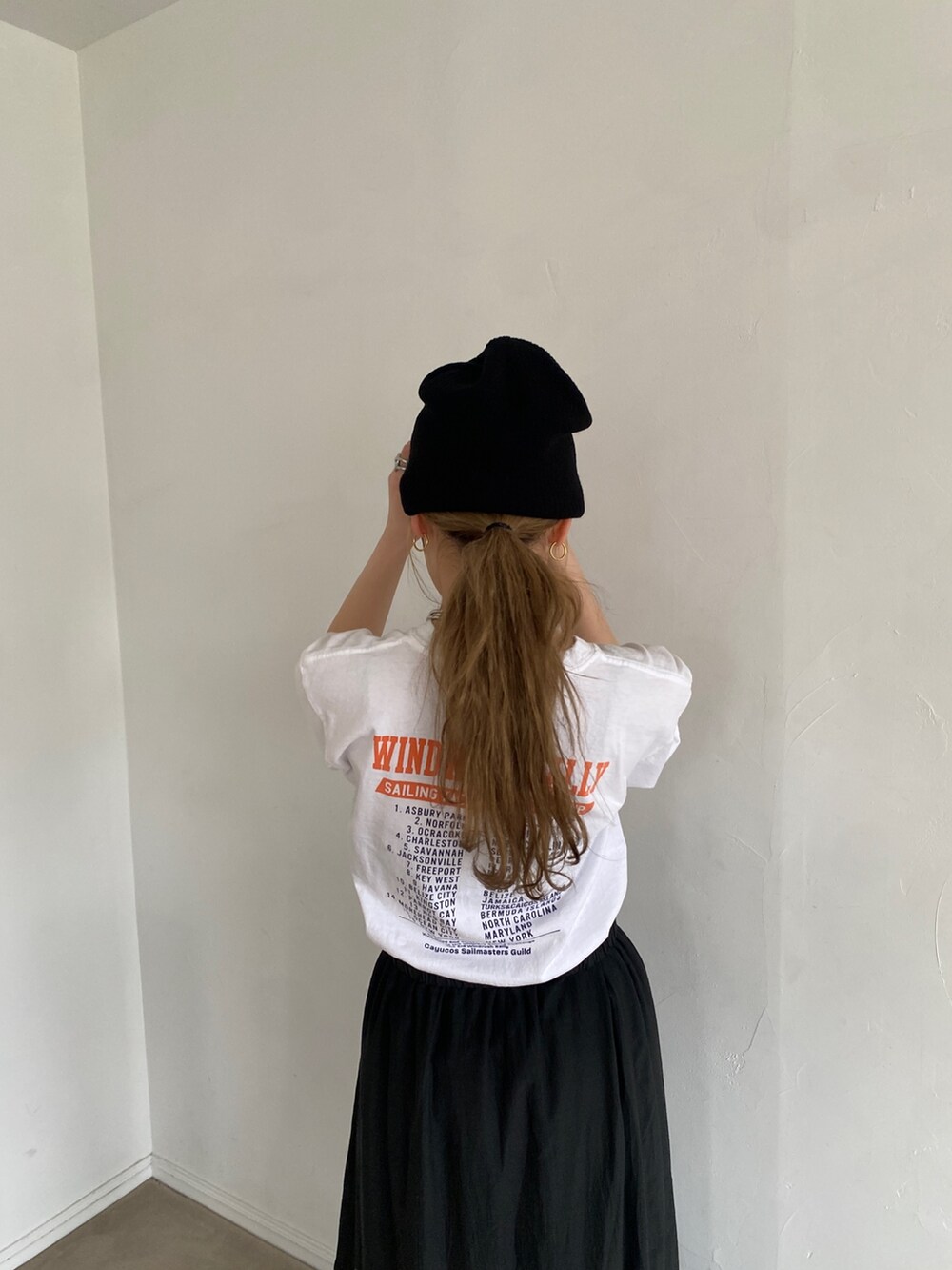 ホワイト系のTシャツ/カットソー、ブラック系のスカートを着用したレディースの春コーディネートの3枚目の写真