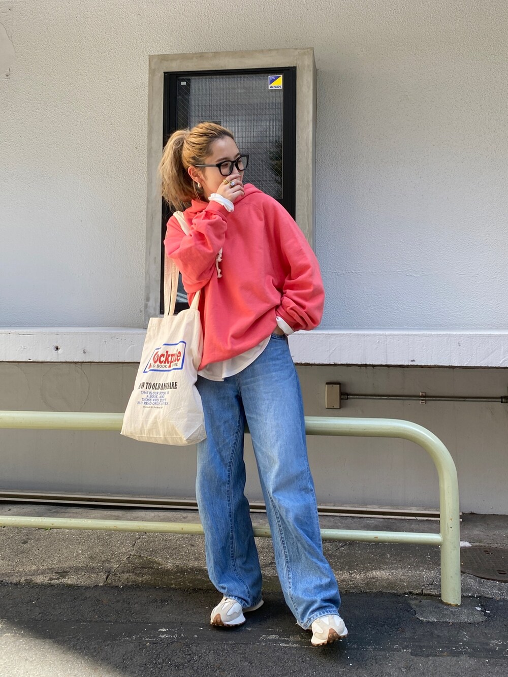 ピンク系のパーカー、ホワイト系のTシャツ/カットソー、ブルー系のデニムパンツを着用したレディースの秋コーディネートの3枚目の写真