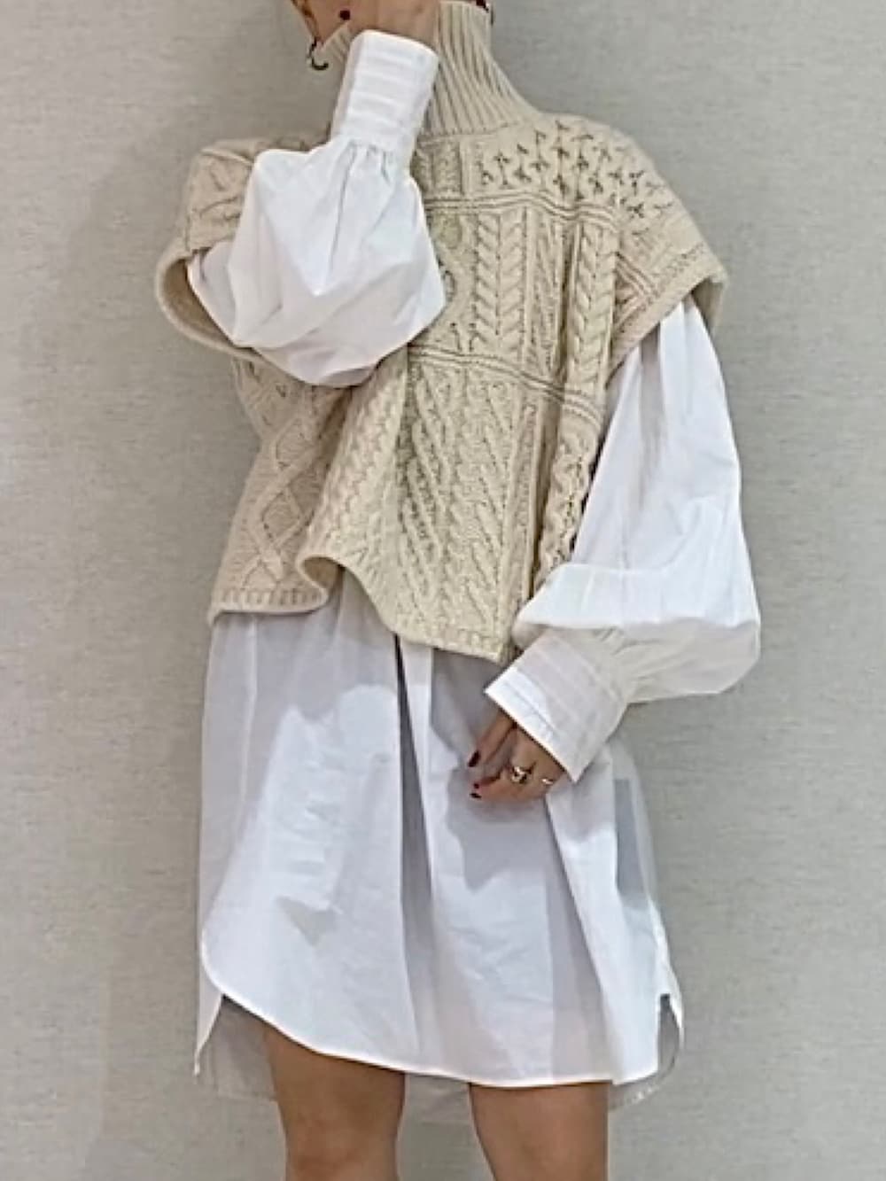 ホワイト系のシャツ/ブラウス、ホワイト系のニット/セーター、ブラック系のブーツを着用したレディースの秋コーディネートの6枚目の写真