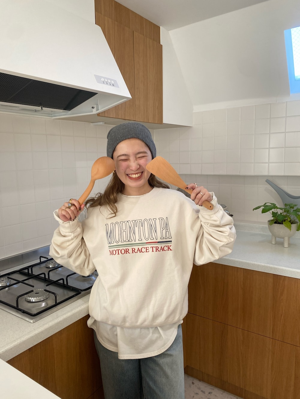 ホワイト系のスウェット、ホワイト系のTシャツ/カットソー、ブルー系のデニムパンツを着用したレディースの冬コーディネートの3枚目の写真