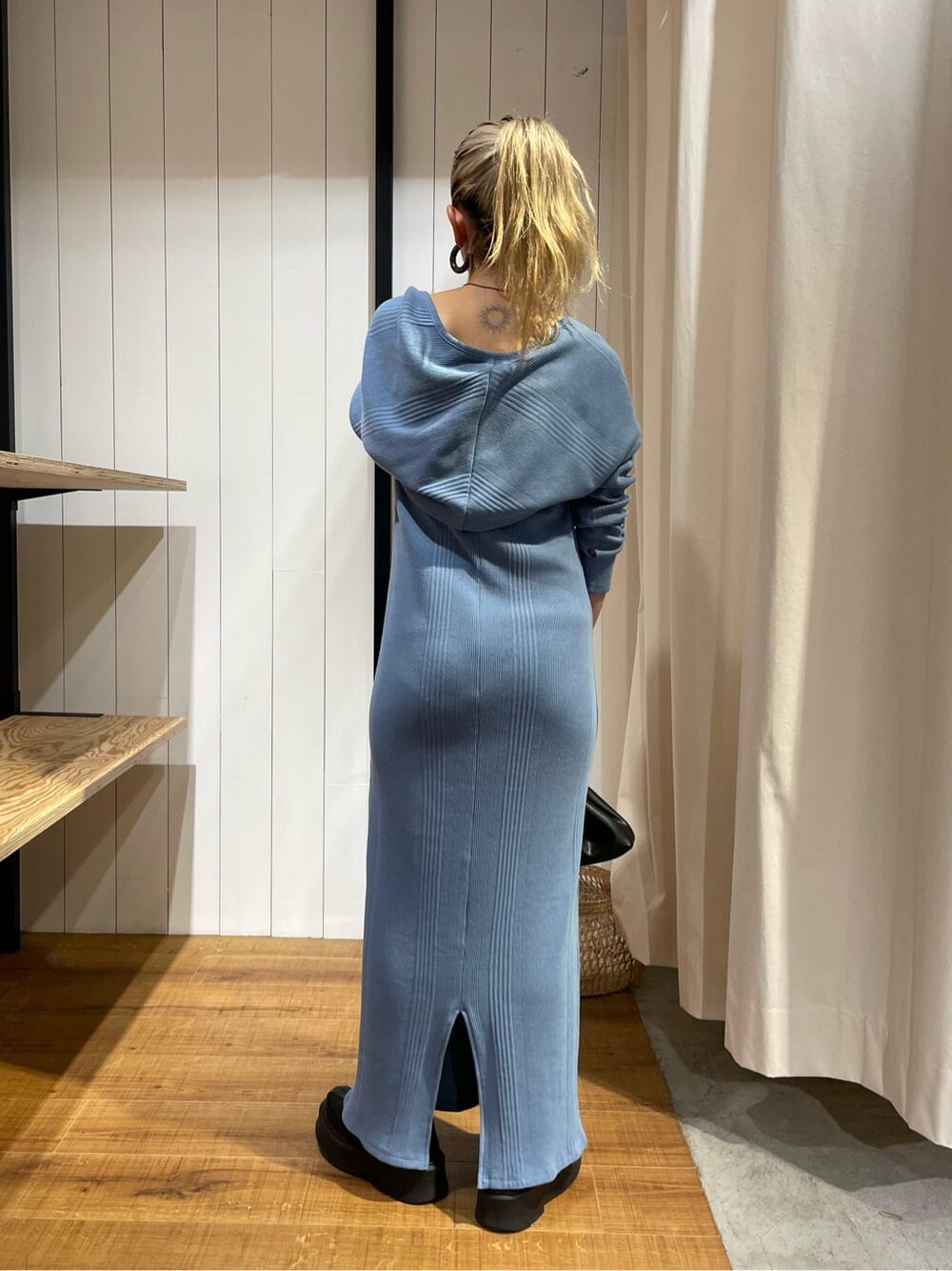 ブラック系のブーツ、ブルー系のワンピース、ブラック系のクラッチバッグを着用したレディースの秋コーディネートの3枚目の写真