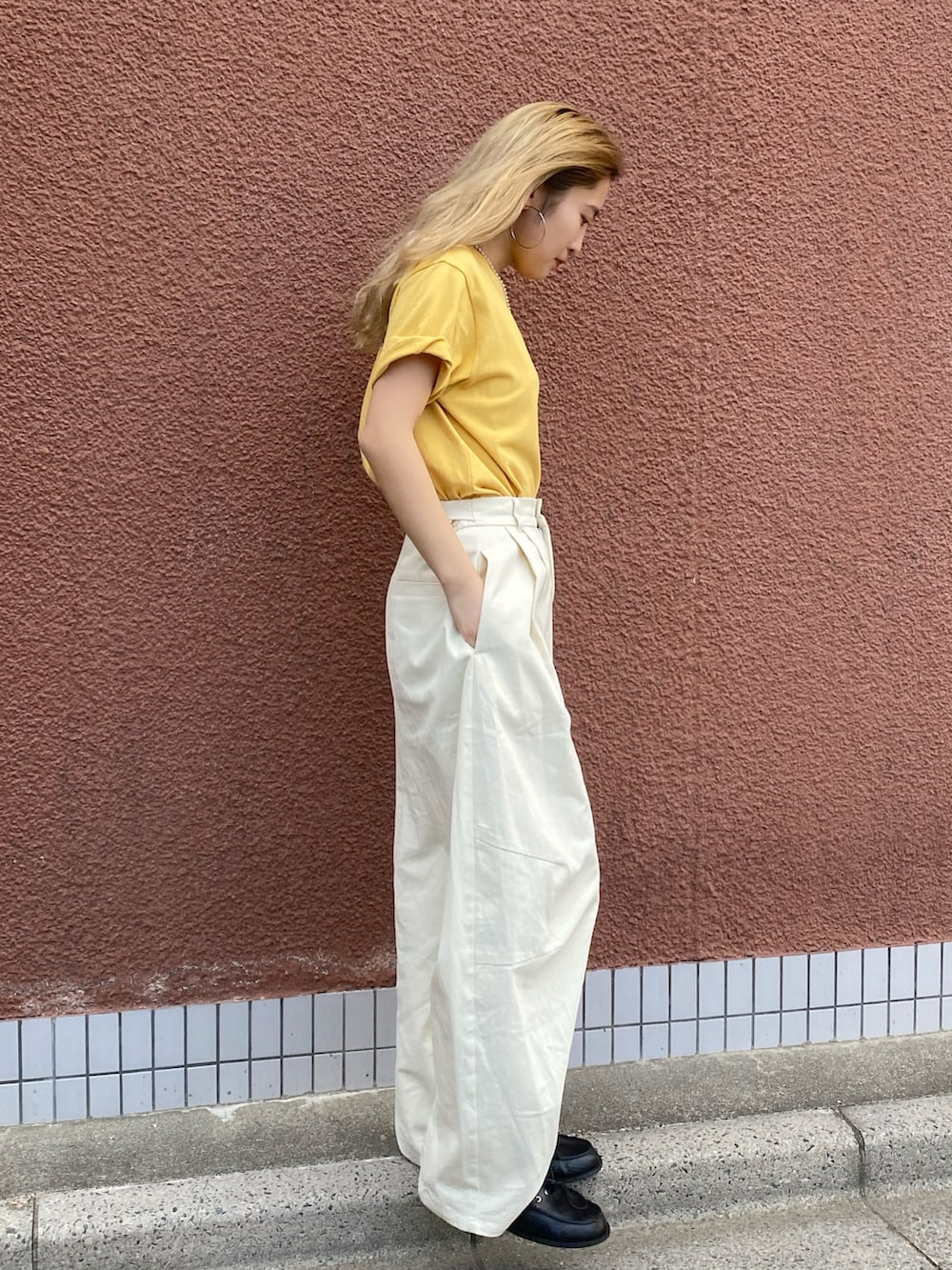 イエロー系のTシャツ/カットソー、ホワイト系のチノパンツを着用したレディースの夏コーディネートの2枚目の写真