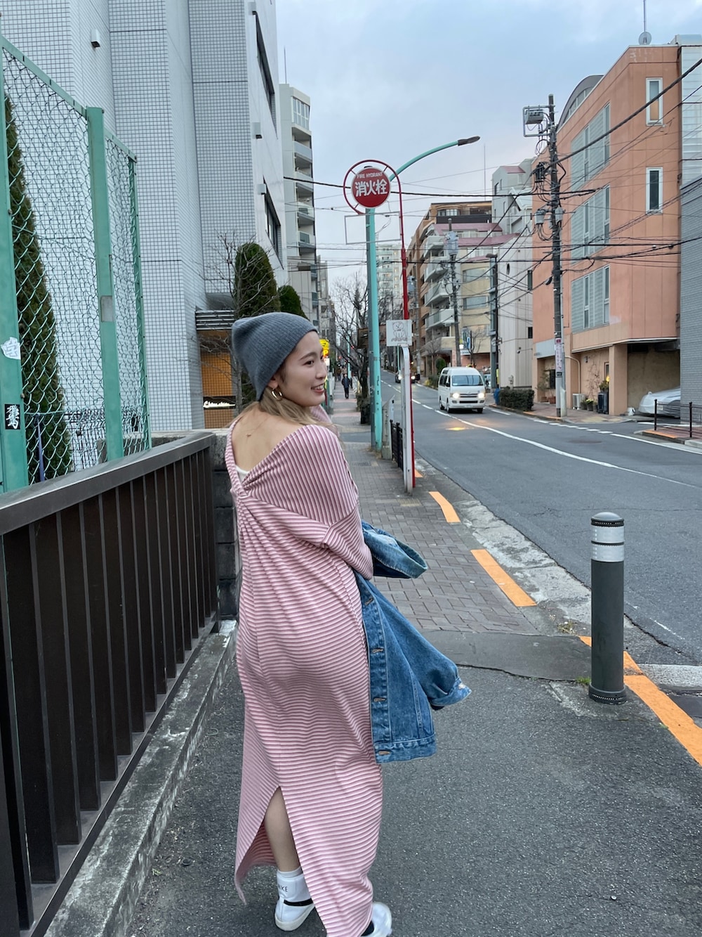 ピンク系のワンピース、ブルー系のデニムジャケット、グレー系のニットキャップ/ビーニーを着用したレディースの冬コーディネートの9枚目の写真