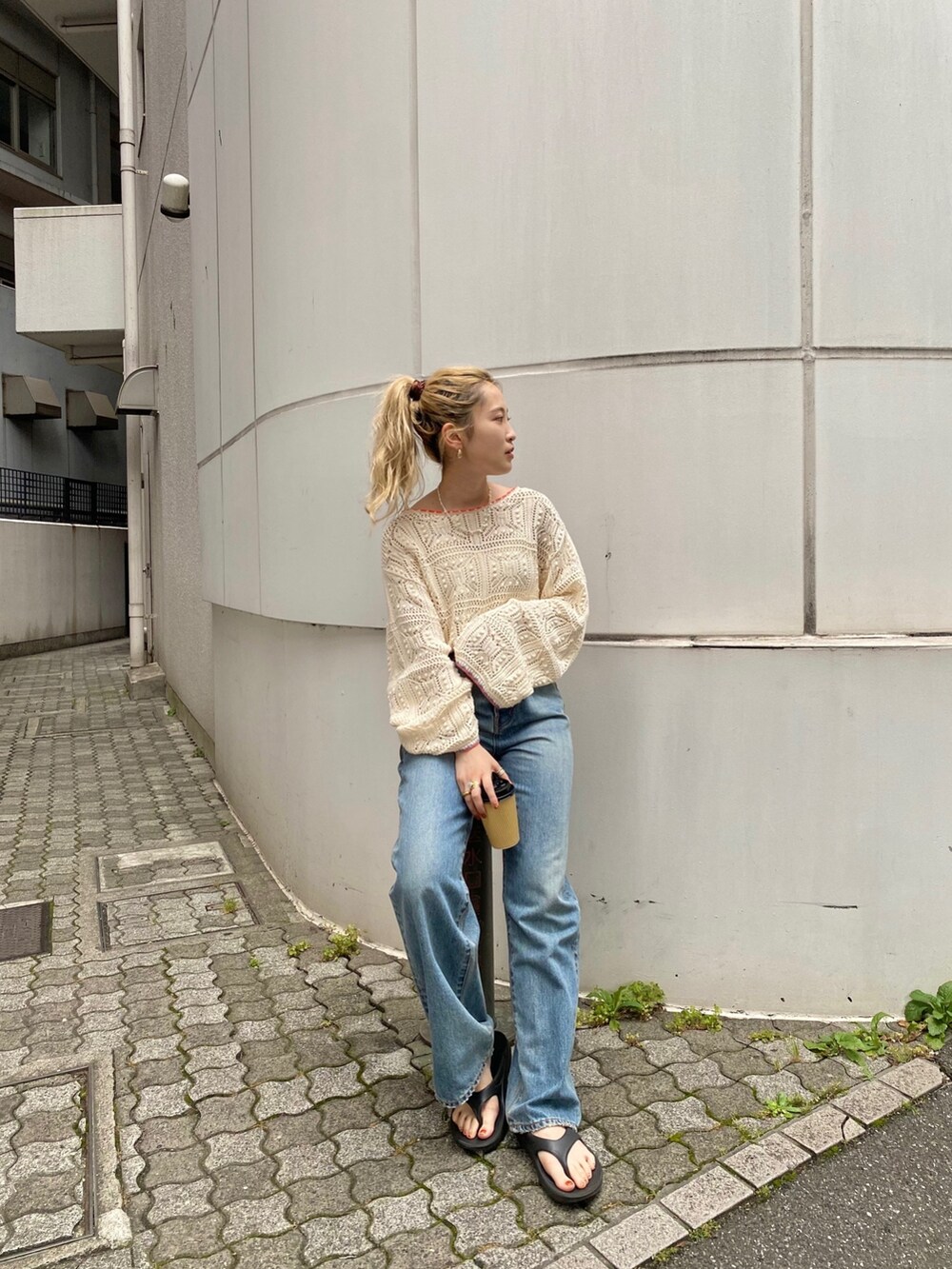 ホワイト系のキャミソール、ホワイト系のニット/セーター、ブルー系のデニムパンツを着用したレディースの夏コーディネートの2枚目の写真