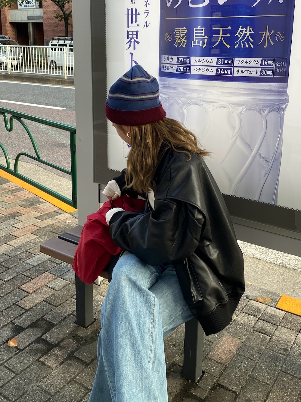 ブラック系のブルゾン、ホワイト系のTシャツ/カットソー、レッド系のトートバッグを着用したレディースの秋コーディネートの4枚目の写真