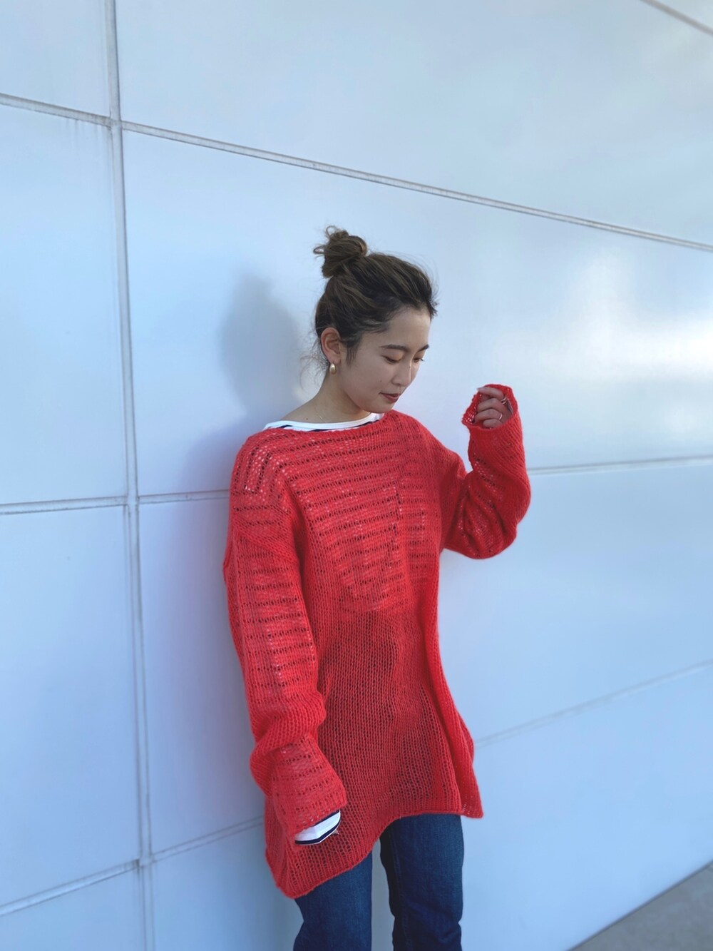 オレンジ系のニット/セーター、ブルー系のTシャツ/カットソーを着用したレディースの冬コーディネートの6枚目の写真