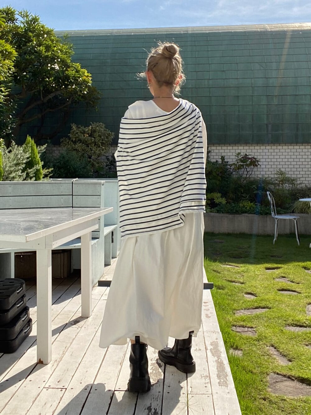 オレンジ系のハンドバッグ、オレンジ系のワンピース、ブルー系のTシャツ/カットソーを着用したレディースの秋コーディネートの4枚目の写真