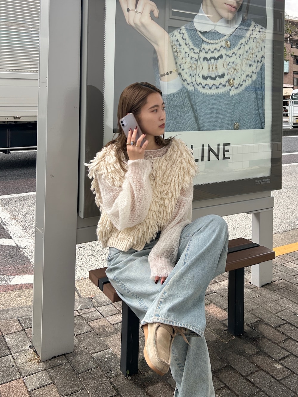 ホワイト系のベスト、ホワイト系のニット/セーター、ブルー系のデニムパンツを着用したレディースの秋コーディネートの4枚目の写真