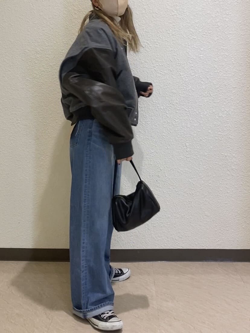 グレー系のブルゾン、ホワイト系のニット/セーター、ブルー系のデニムパンツを着用したレディースの秋コーディネートの3枚目の写真