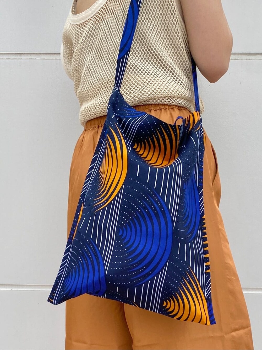 ブラック系のサンダル、オレンジ系のその他パンツ、ブルー系のショルダーバッグを着用したレディースの春コーディネートの8枚目の写真