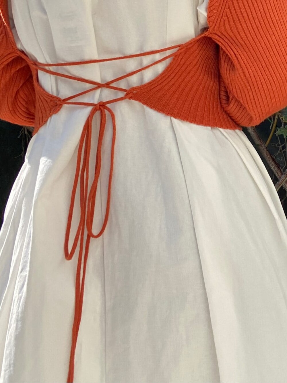 オレンジ系のワンピースを着用したレディースの秋コーディネートの8枚目の写真