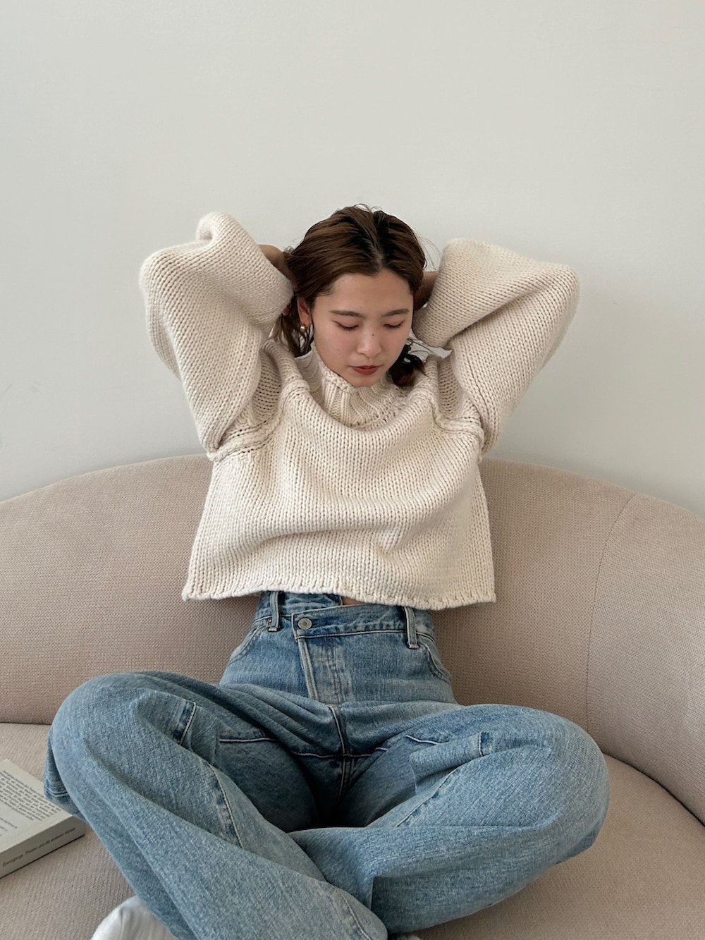 ホワイト系のニット/セーター、ブルー系のデニムパンツを着用したレディースの冬コーディネートの4枚目の写真